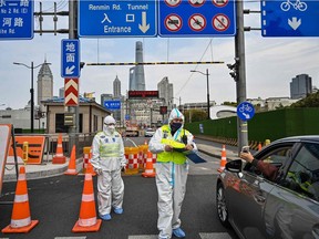 A police officer, wearing a protective gear, controls access to a tunnel in the direction of Pudong district in lockdown as a measure against the COVID-19 coronavirus, in Shanghai on March 28, 2022. Millions of people in China’s financial hub were confined to their homes as the eastern half of Shanghai went into lockdown to curb the nation’s biggest COVID outbreak.