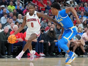 Arizona Wildcats guard Bennedict Mathurin dribbles against UCLA Bruins guard Jaylen Clark during the second half at T-Mobile Arena in Las Vegas on March 12, 2022.