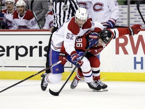 Montreal Canadiens defenseman Justin Barron battles for the puck with New Jersey Devils centre Jack Hughes during the third period on March 27, 2022, in Newark, N.J.