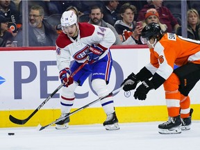 Montreal Canadiens' Nick Suzuki, left, passes the puck against Philadelphia Flyers' Travis Sanheim during the third period on March 13, 2022, in Philadelphia.