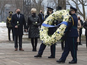 Health workers carry a wreath as Premier François Legault, left, and his wife Isabelle Brais look on during a ceremony for the victims of COVID-19 on Thursday, March 11, 2021 at the legislature in Quebec City.