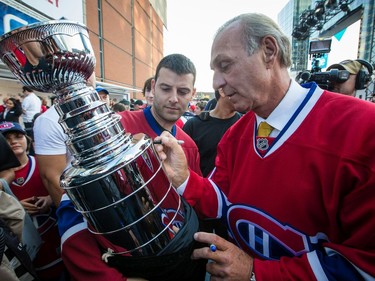 MONTREAL, QUE.: OCTOBER 1, 2013 -- Canadiens fan Mario Fargnoli, left, gets his novelty Stanley Cup trophy signed by Canadiens hockey legend Guy Lafleur during pre-game festivities before the NHL hockey season opening match between the Montreal Canadiens and the Toronto Maple Leafs in Montreal on Tuesday, October 1, 2013. (Dario Ayala / THE GAZETTE) ORG XMIT: 48038 ORG XMIT: POS1310011655128749 ORG XMIT: POS1310011911059036