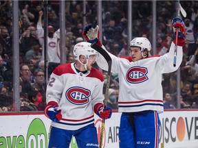 Montreal Canadiens' Artturi Lehkonen, left, of Finland, and Jake Evans celebrate Lehkonen's second goal against the Vancouver Canucks during the second period of an NHL hockey game in Vancouver, on Wednesday, March 9, 2022.