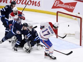 Canadiens' Josh Anderson scores on Jets goaltender Connor Hellebuyck as Dylan DeMelo defends Tuesday night in Winnipeg. Anderson notched his first career hat trick in his team's 8-4 loss.