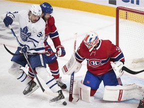 Toronto Maple Leafs' Auston Matthews (34) moves in on Canadiens goaltender Jake Allen as Canadiens' Joel Armia (40) defends during first period NHL hockey action in Montreal on Saturday, March 26, 2022.