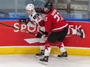 Canada's Justin Barron checks Switzerland's Inaki Baragano during first period of world junior championship game in Edmonton on Dec. 29, 2020.