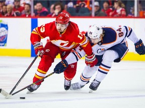 Edmonton Oilers defenceman William Lagesson checks Flames forward Johnny Gaudreau during game in Calgary on March 7, 2022.