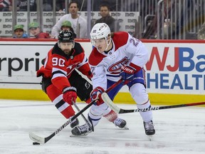 Canadiens' Cole Caufield (22) and New Jersey Devils' Tomas Tatar (90) battle for the puck at the Prudential Center on Sunday, March 27, 2022, in Newark, N.J.