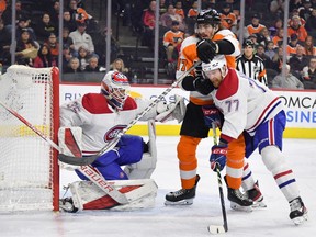 Philadelphia Flyers centre Zack MacEwen (17) and Canadiens defenceman Brett Kulak (77) battle for position in front of goaltender Sam Montembeault during the second period at Wells Fargo Center on Sunday, March 13, 2022, in Philadelphia.