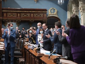 Quebec Finance Minister Eric Girard, centre is applauded by members of the government as he presents the government's budget, Tuesday, March 22, 2022 at the legislature in Quebec City.