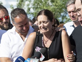 Amélie Lemieux is comforted by family members while speaking at a memorial for her two daughters, Romy and Norah, in Lévis in July 2020.