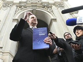 Quebec Finance Minister Eric Girard  responds to reporters questions on the eve of a budget speech, Monday, March 21, 2022 outside the finance ministry in Quebec City.