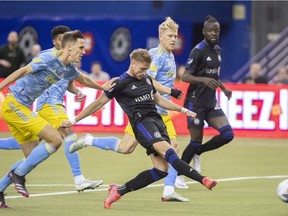 CF Montréal's Djordje Mihailovic, centre, takes a shot on goal as Philadelphia Union players defend during second half MLS soccer action in Montreal on Saturday, March 5, 2022.