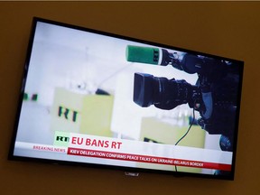 A camera and a microphone of the RT channel TV is seen on a TV screen in a hotel during a live news broadcast of the Russia Today (RT) channel TV, after Russia launched a massive military operation against Ukraine, in Madrid, Spain, February 27, 2022. REUTERS/Jon Nazca