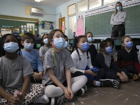 Students at St. Monica Elementary School listen as a book is read to them in January while teacher Brynne Warner looks on.