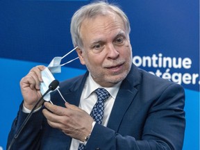 Interim Quebec public health director Dr. Luc Boileau removes his mask prior to a press conference.