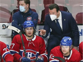 Canadiens assistant coach Luke Richardson has a conversation with defenceman Alexander Romanov as teammate Kale Clague looks on during second period against the Washington Capitals in Montreal on Feb. 10, 2022.