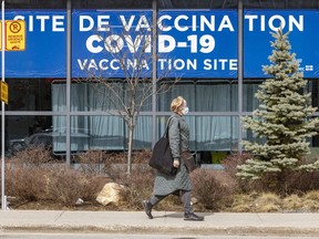 2022년 4월 11일 월요일, 몬트리올의 파르크 거리에 있는 COVID-19 예방접종 클리닉을 통과하는 여성.