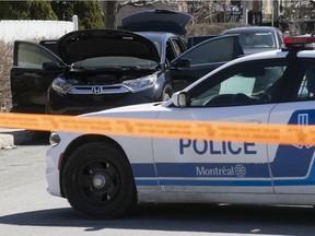 Montreal police next to a suspected getaway car found at the corner of Montpetit and Follereau, after a shooting at the entrance of a drive-through car wash on Métropolitain Blvd. on April 12, 2022.