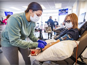 Auxiliary nurse Melissa Robles connects tube to donor Nathalie Drouin-Courtois who was donating plasma at Héma-Québec's Globule blood donor clinic in Kirkland.