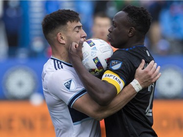 Victor Wanyama (right) of CF Montréal and Lucas Cavallini of the Vancouver Whitecaps FC get the ball between them in MLS play Saturday, April 16, 2022, at Saputo Stadium.