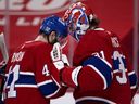 Montreal Canadiens goaltender Carey Price taps helmets with  winger Paul Byron after beating the Vancouver Canucks in Montreal on Feb. 1, 2021.