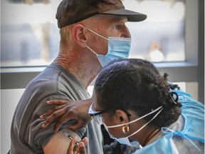 John Montgomery recieves COVID-19 vaccine shot from nurse Tayshe Dupueronette at a vaccination clinic organized by the Resilience Montreal day shelter in April 2021.