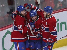 Mike Hoffman (left) is congratulated by Montreal Canadiens teammates Nick Suzuki (right) and Cole Caufield (centre) in the first period  in NHL action at the Bell Centre in Montreal Friday, April 29, 2022.