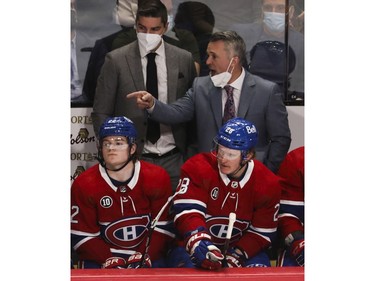 Montreal Canadiens head coach Martin St-Louis speaks behind the bench in the third period during a game against the Florida Panthers at the Bell Centre in Montreal on Friday, April 29, 2022.  In front of him are Cole Caufield (left) and Christian Dvorak. In the upper left is assistant coach Alex Burrows.