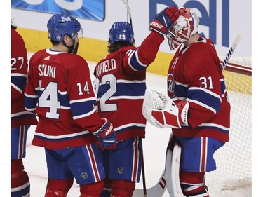Canadiens players Nick Suzuki and Cole Caufield congratulate Carey Price at the end of the game against the Florida Panthers at the Bell Centre in Montreal on Friday, April 29, 2022.