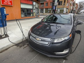An electric car is hooked up to a curbside charging station in Montreal. Quebec wants electric vehicles to constitute 100 per cent of new car sales in the province by 2035.