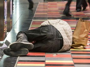 An unidentified man sleeps beside garbage cans inside the Guy Concordia métro station.