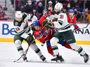 Montreal Canadiens winger Brendan Gallagher tries to squeeze past Minnesota Wild's Mitchell Chaffee, left, and Brandon Duhaime during the second period at the Bell Centre in Montreal on April 19, 2022.