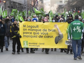 Striking government workers walk along St-Antoine St. on March 30, 2022 during their first day of strike.