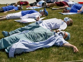Saying they are "dead from fatigue," health-care workers protest against their working conditions outside a Montreal hospital in May 2020. While the health-care system has been ailing for some time, "COVID mercilessly increased the strain," Fariha Naqvi-Mohamed writes.