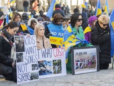 People take a knee during a rally in support of Ukraine outside the Notre-Dame Basilica in Montreal on Saturday, April 2, 2022.
