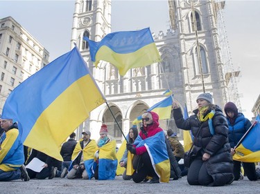 People take a knee during a rally in support of Ukraine outside the Notre-Dame Basilica in Montreal on Saturday, April 2, 2022.