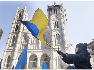 A child waves a Ukrainian flag during a rally in support of Ukraine outside the Notre-Dame Basilica in Montreal on Saturday, April 2, 2022.