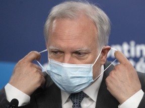 Quebec interim public health director Dr. Luc Boileau removes his mask as he arrives to give a COVID-19 update, Thursday, April 21, 2022 in Montreal.