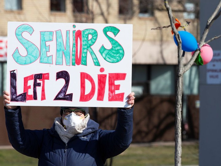  A person holds a sign outside CHSLD Herron, a long-term care facility, following a number of deaths since the COVID-19 outbreak, in Dorval on April 11, 2020.