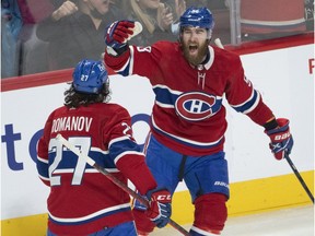 Montreal Canadiens' David Savard celebrates with teammate Alexander Romanov after scoring the first goal against the Boston Bruins, in Montreal on March 21, 2022.