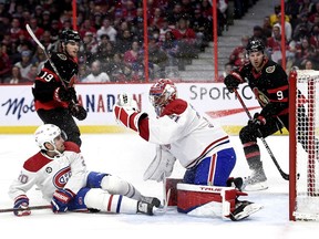 Montreal Canadiens goaltender Carey Price makes a glove save as defenceman Chris Wideman, Ottawa Senators right wing Drake Batherson (19) and centre Josh Norris look on during second period in Ottawa on April 23, 2022.