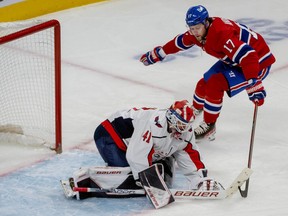Washington Capitals goalie Vitek Vanecek smothers the puck as Canadiens' Josh Anderson (17) looks for a rebound in Montreal on Saturday, April 16, 2022.
