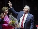 NHL hockey legend Guy Lafleur waves to Quebec Remparts fans as his wife Lise looks on during a ceremony to retire his No. 4 from the QMJHL on Oct. 28, 2021, at the Videotron Centre in Quebec City. 