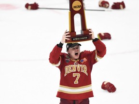 Denver Pioneers forward Brett Stapley (7) celebrates the trophy after the Pioneers defeated the Minnesota State Mavericks in 2022 Frozen Four college ice hockey national championship game at TD Garden.