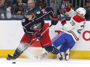 Blue Jackets' Patrik Laine passes the puck after colliding with Canadiens defenceman Jeff Petry during the second period Wednesday, April 13, 2022 at Nationwide Arena in Columbus, Ohio.