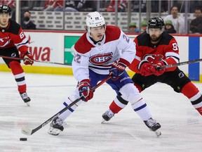 Montreal Canadiens right-wing Cole Caufield shoots while being defended by New Jersey Devils' Tomas Tatar during the first period at Prudential Center in Newark, N.J., on March 27, 2022.