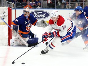Montreal Canadiens centre Nick Suzuki controls the puck as New York Islanders goaltender Ilya Sorokin looks on during the third period at UBS Arena in New York on Feb. 20, 2022.