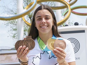 Three-time Olympic medallist Meaghan Benfeito shows off replacement copies of her Olympic and Pan-American Games medals in Montreal in June 2021, after losing the originals along with all her belongings in a condo fire in Mirabel.