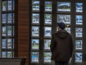 A person looks at real estate bulletins in Toronto.